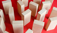Wooden Blocks On A Red Background. The Concept Of A Labyrinth Of Wardrobes Or Dense Urban Construction. Barriers And Obstacles. Objects And Structures. View From Above