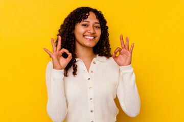 Wall Mural - Young mixed race woman isolated on yellow background cheerful and confident showing ok gesture.