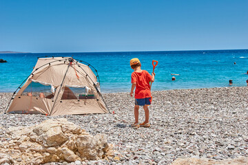 The amazing Kaladi beach, beautiful scenery with a young child, a boy playing on the beach. Ionian, Greece, Europe