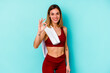 © Asier - Young sport caucasian woman isolated on blue background cheerful and confident showing ok gesture.