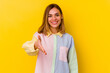 © Asier - Young caucasian skinny woman isolated on yellow background stretching hand at camera in greeting gesture.