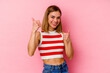 © Asier - Young caucasian woman isolated on pink background raising both thumbs up, smiling and confident.