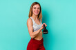 © Asier - Young sport skinny caucasian holding a dumbbell woman isolated on blue background