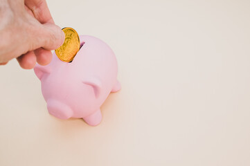 Sticker - Hand putting a gold coin into a piggy bank