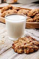 Close-up homemade oatmeal cookies and glass milk. Homemade gluten and sugar free recipe. Rustic wooden background and linen napkin. Delicious and healthy sweets. Breakfast