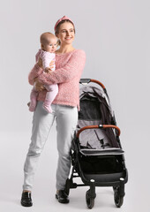 Wall Mural - Woman with her cute baby and stroller on white background