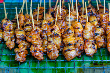 Thai street vendor sells grilled chicken meat at street food market , Thailand. Close up