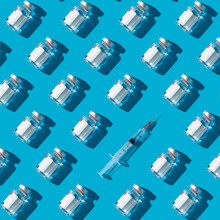 Vaccine Vials And Syringe On A Cyan Background , Flat Lay Pattern Minimalistic Concept