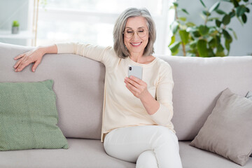 Sticker - Portrait of attractive cheerful woman sitting on divan using device chatting browsing web pastime at home house apartment flat indoor