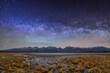 Starry milky way sky over lake and mountains in autumn.