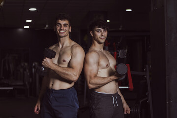 two young athletes posing in a gym after doing sports