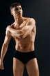 © SHOTPRIME STUDIO - sporty man with naked muscular body in the dark in shorts posing macho dark background