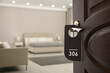 © New Africa - Wooden door open into modern hotel room, closeup