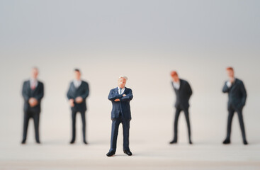 Poster - Close-up of miniature figure of one businessman standing out from the crown of others businessmen , Leadership concept.