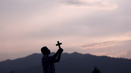 Wall Mural - Young christian praying with Cross on the hill, christian silhouette concept.