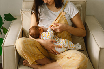 Wall Mural - newborn baby boy sucking milk from mothers breast. portrait of mom and breastfeeding baby.