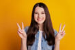 Portrait of lovely friendly woman showing victory peace sign