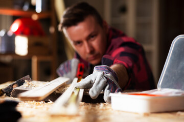 Wall Mural - Young carpenter working in workshop. Man working on wood craft at workshop.