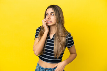 Wall Mural - Young caucasian woman isolated on yellow background is a little bit nervous