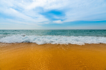 Soft blue ocean wave on clean sandy beach