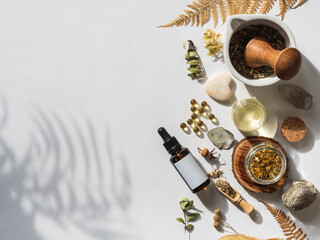 Organic natural product - oils, various dry plants and glass bottle mockup on white background