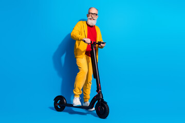 Wall Mural - Full body portrait of cheerful aged man stand on vehicle beaming smile look camera isolated on blue color background