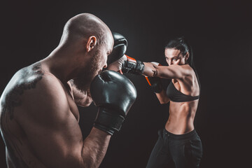 Wall Mural - Shirtless Woman exercising with trainer at boxing and self defen