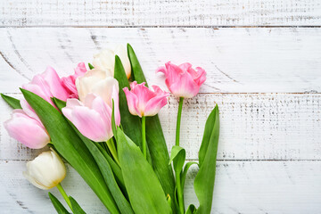 Pink and white tulips on white wooden background. Floral pattern. Greeting card.  Mock up. Space for text.