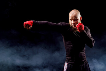 Wall Mural - Sportsman boxer fighting on black background with smoke. Boxing