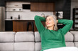 © Vadim Pastuh - Carefree retired woman rests on the couch at home. Charming senior female feels free from anxiety or responsibility, dreaming with eyes closed