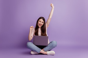 Wall Mural - Photo of girl with laptop raise hands celebrate victory on purple background