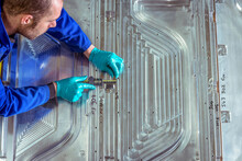 UK, Close-up Of Engineer Measuring Metal Machine Part In Factory