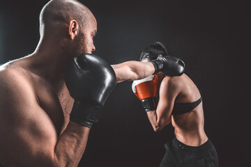 Wall Mural - Shirtless Woman exercising with trainer at boxing and self defen