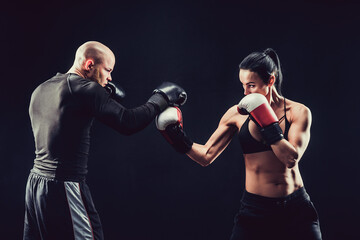 Wall Mural - Shirtless Woman exercising with trainer at boxing and self defen