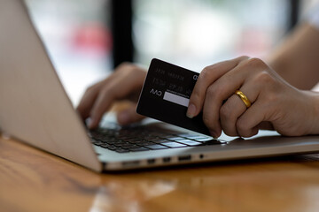 Close up woman hand using credit card and smartphone laptop for buying online shopping