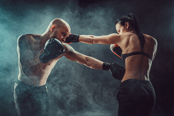 Wall Mural - Shirtless Woman exercising with trainer at boxing and self defen