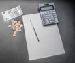 Billete, monedas, calculadora, bolígrafo y papel . Problemas de dinero al final de mes