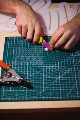 Wall Mural - Cropped view of man cutting flex neon near wire cutters 