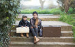 © Olga - Children a boy and a girl sit sad because they are lost. They're on a journey. they are wearing fashionable vintage clothes, в руках карта и чемодан