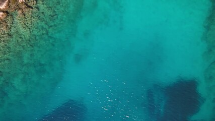 Wall Mural - Aerial view of turquoise and clear sea water surface at sunny day. Summer holiday and travel to sea