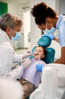 Little boy having dental examination by two dentists at dental clinic.