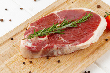 Wall Mural - Raw lamb steak on board on white wooden table