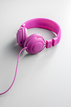 Pink Wired Stereo Headphones On Gray Background.