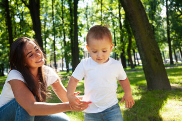 young pretty brunette mother with little cute boy walking in park happy smiling, lifestyle people concept