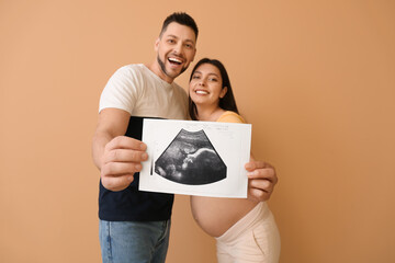 Wall Mural - Beautiful pregnant couple with sonogram image on color background