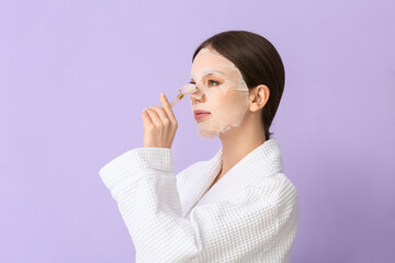 Sticker - Beautiful young woman with sheet facial mask and massage tool on color background