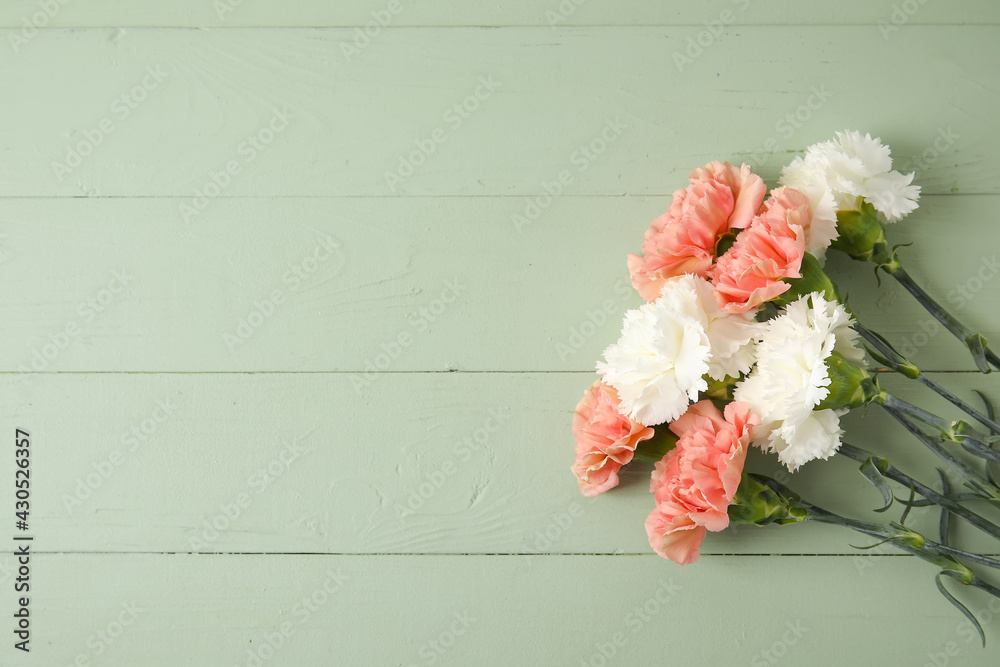 Fresh carnation flowers on color wooden background