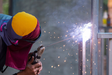 Wall Mural - The new fence iron is being assembled by a skilled Thai iron welder.