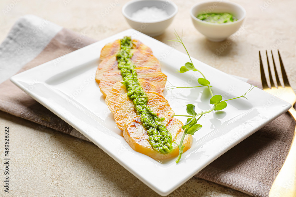 Tasty grilled potatoes with pesto sauce on light background, closeup