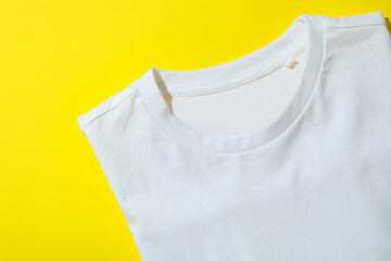 Folded sweatshirt on yellow background, space for text